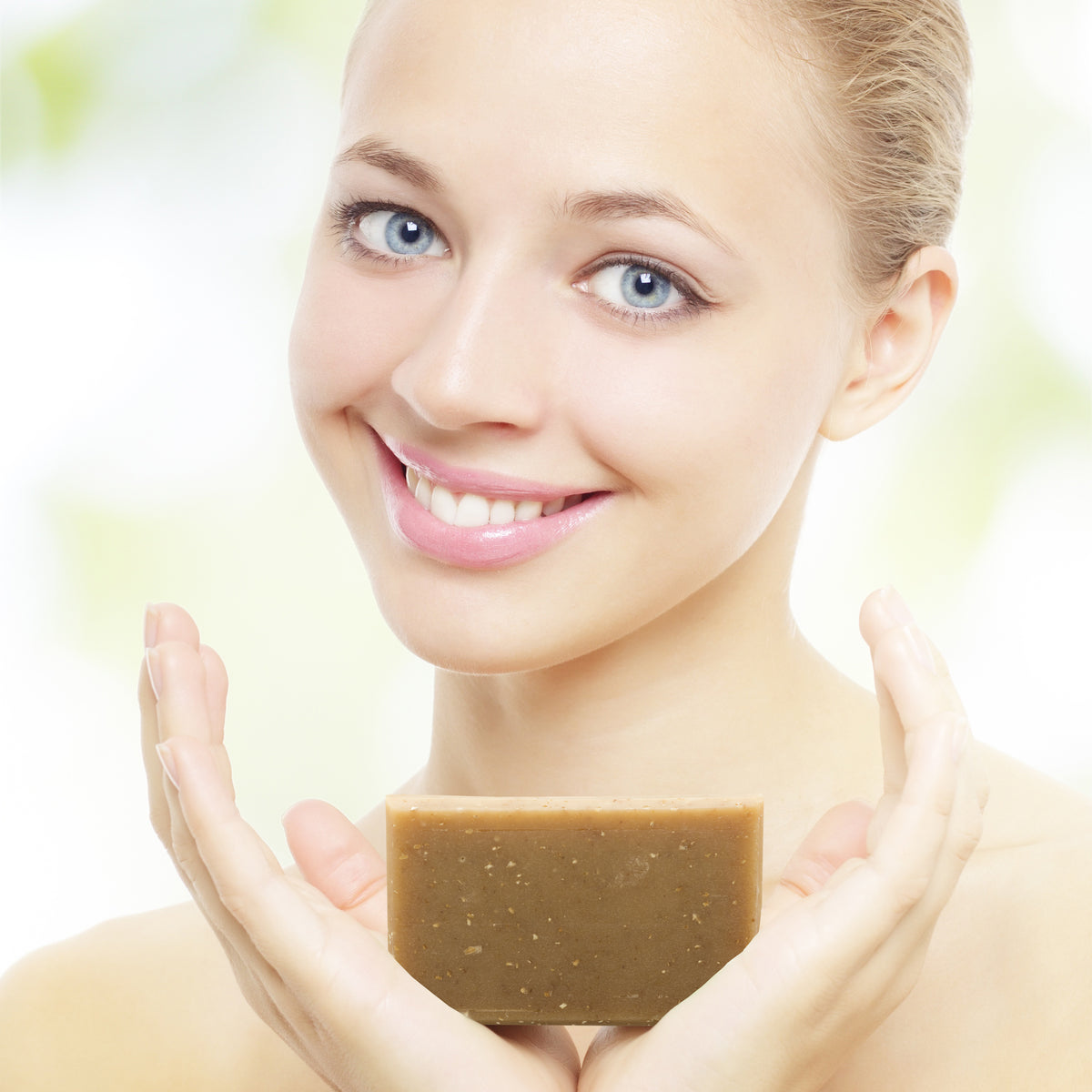 Woman holding Beessential Honey & Oat Bar Soap - Gentle exfoliation and nourishment for glowing skin.